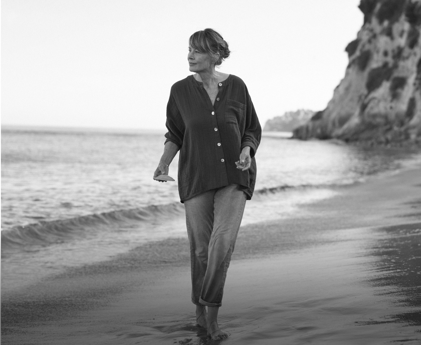 Woman at beach holding shells