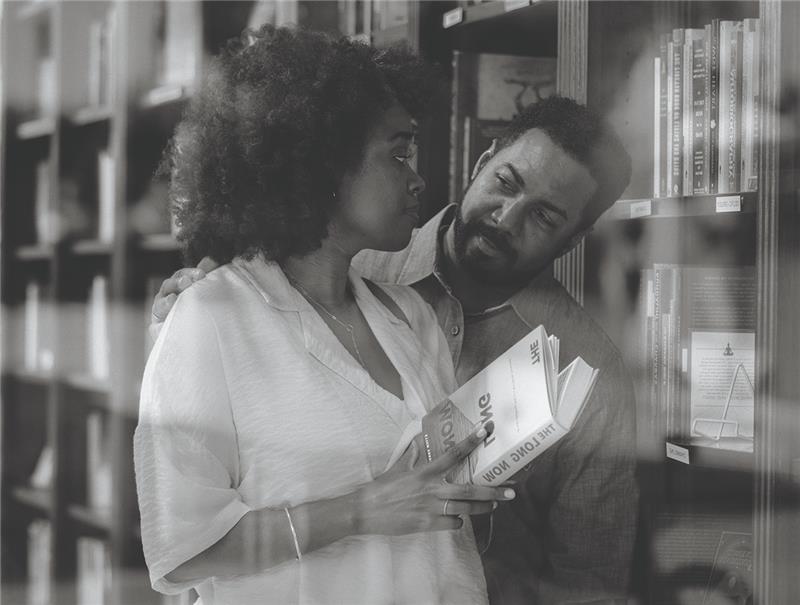Man and woman look at each other in library